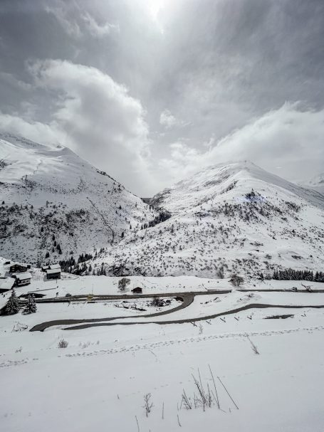 Unterwegs mit dem Zug auf der Glacier-Express Strecke Kurvenreiche Straße zwischen schneebedeckten Bergen