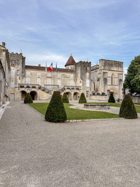 Klassische Schlossanlage mit gepflegtem Garten und grünen Hecken.