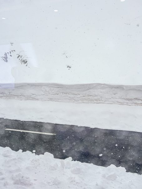 Schneemassen neben der Straße Schneebedeckte Landschaft mit Straße durch die Berge