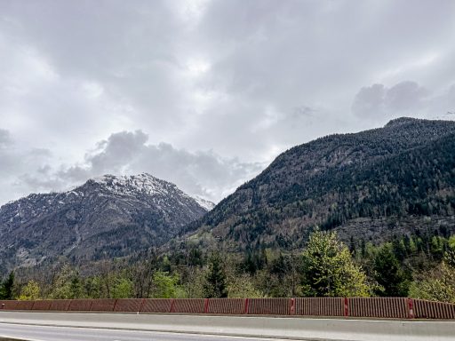 Blick auf bewaldete Berghänge unter bewölktem Himmel