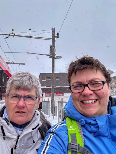 Zwei Personen an einem Bahnhof in winterlicher Umgebung