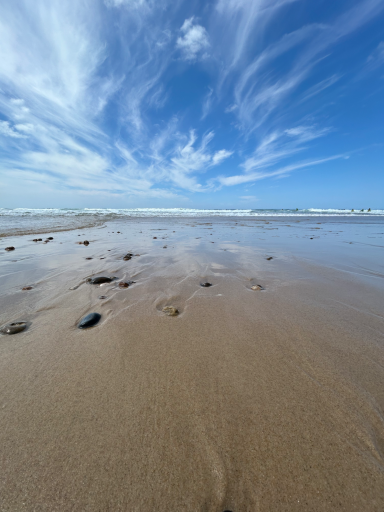 Feuchter Sandstrand mit Wolkenspiegelung bei Ebbe
