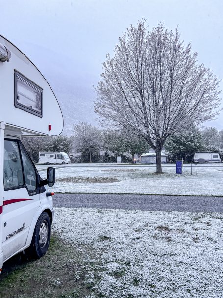 Schnee am Morgen Wohnmobil vor frostigem Baum in verschneiter Landschaft